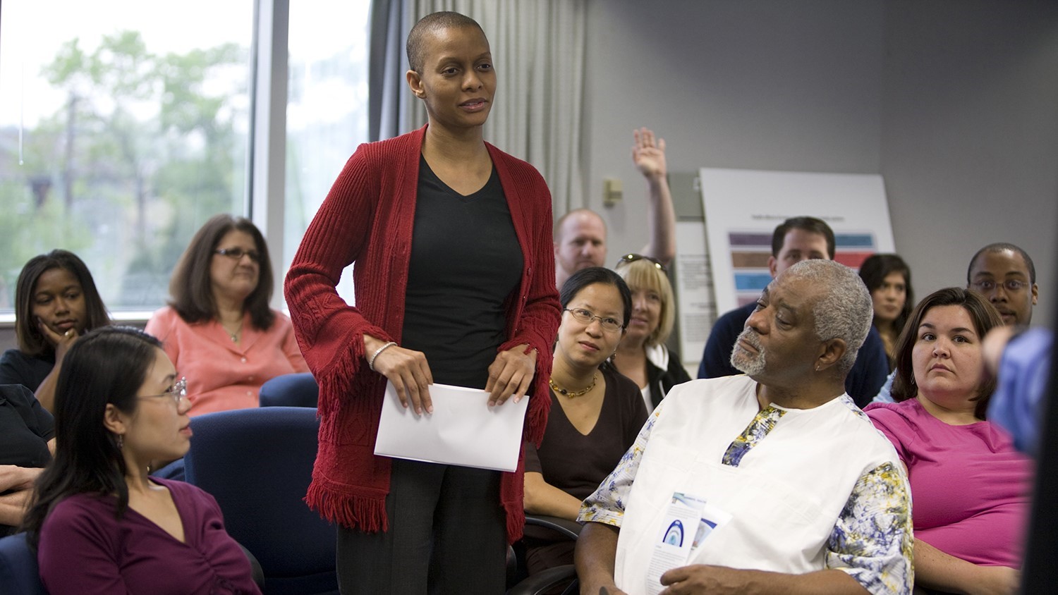 An African American woman attends a town hall meeting conducted on behalf of the ATSDR about local environmental issues.