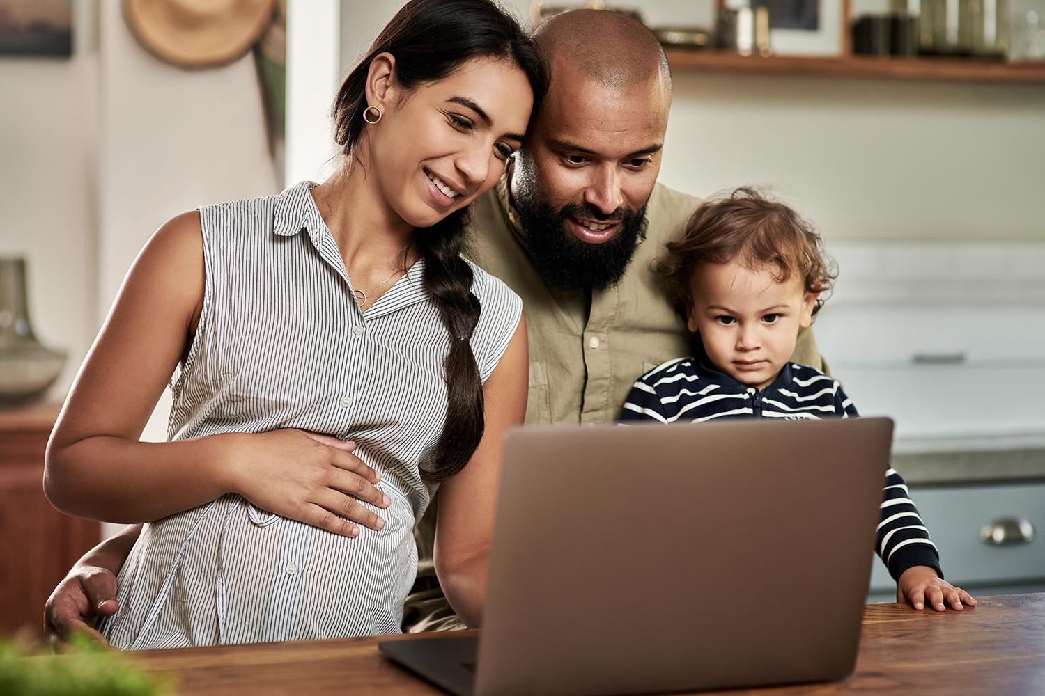 Shot of a happy young family using a laptop together at home