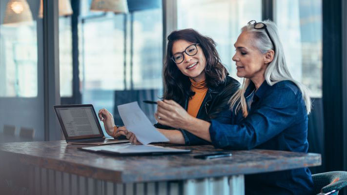 A couple of women looking at a paper.