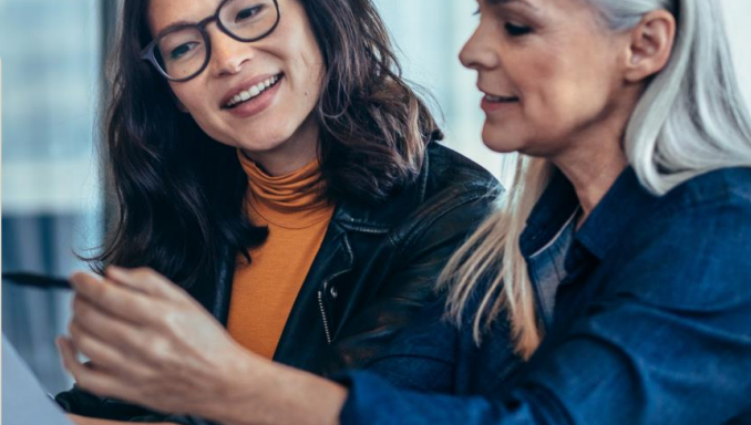 older woman and woman in glasses looking at paper together