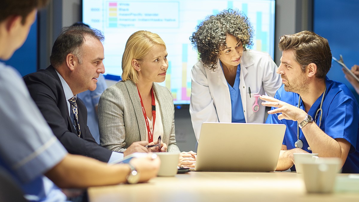 Group of professionals in discussion with a computer