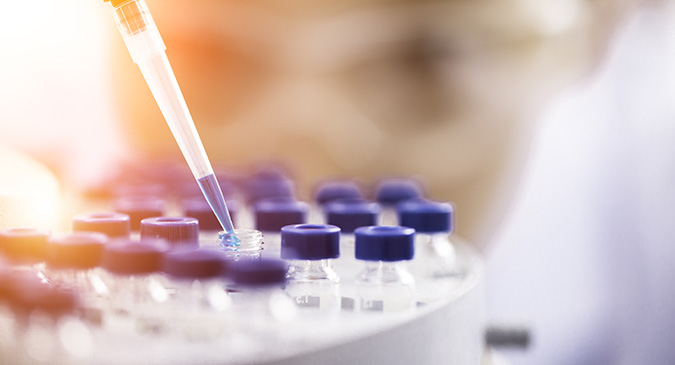 female chemist pipetting liquid into sample vials