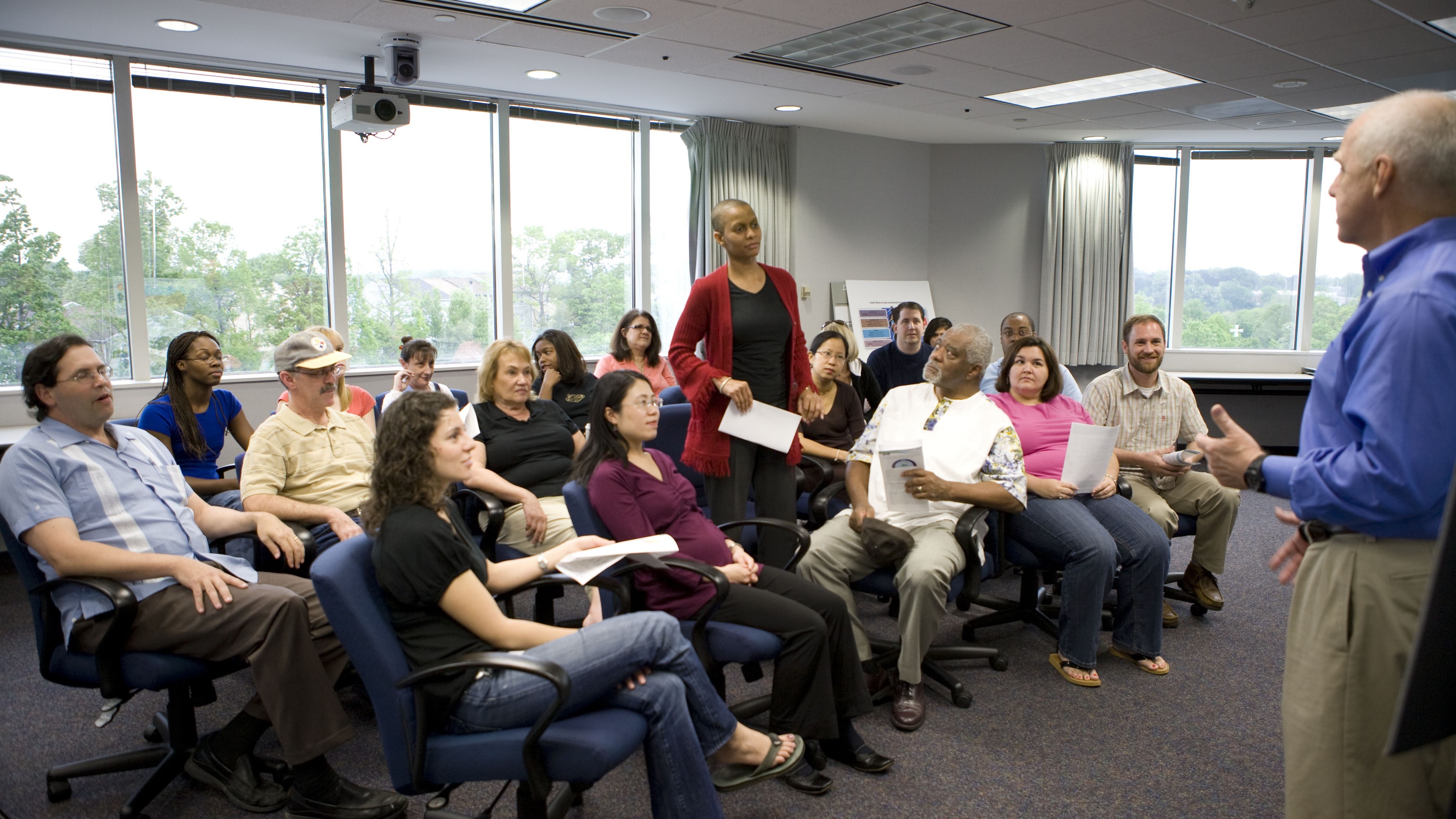 African American woman posing a question to one of the male presenters in an ATSDR town hall meeting