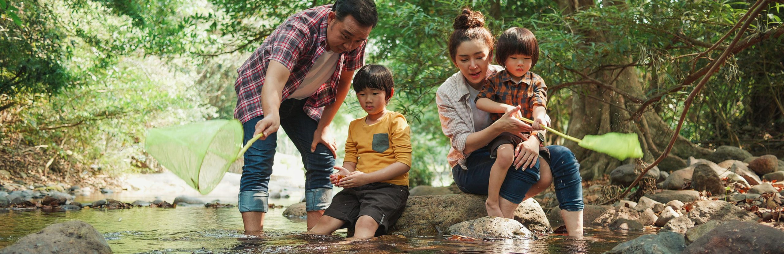 family playing in a creek