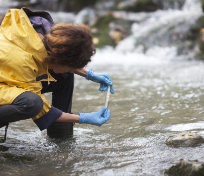 Ecologista investigador tomando una muestra de agua en el bosque