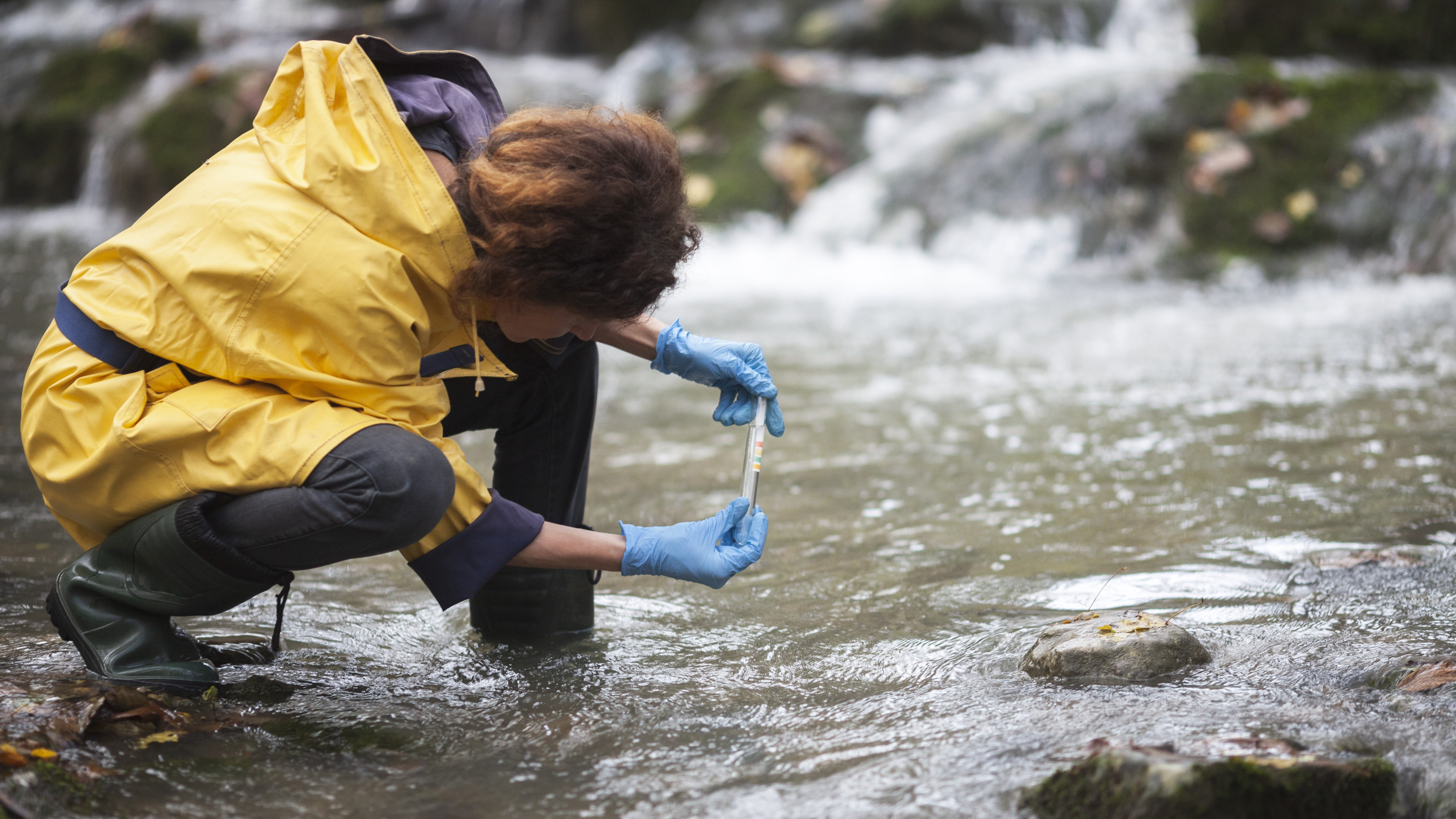 Female by a stream testing the water