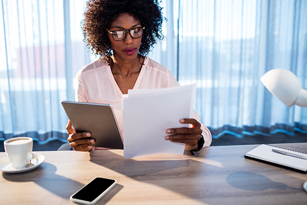 Businesswoman holding a tablet and reading a document