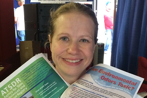 Young lady holding up promotional materials