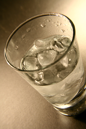 Glass of water with ice sitting on a table