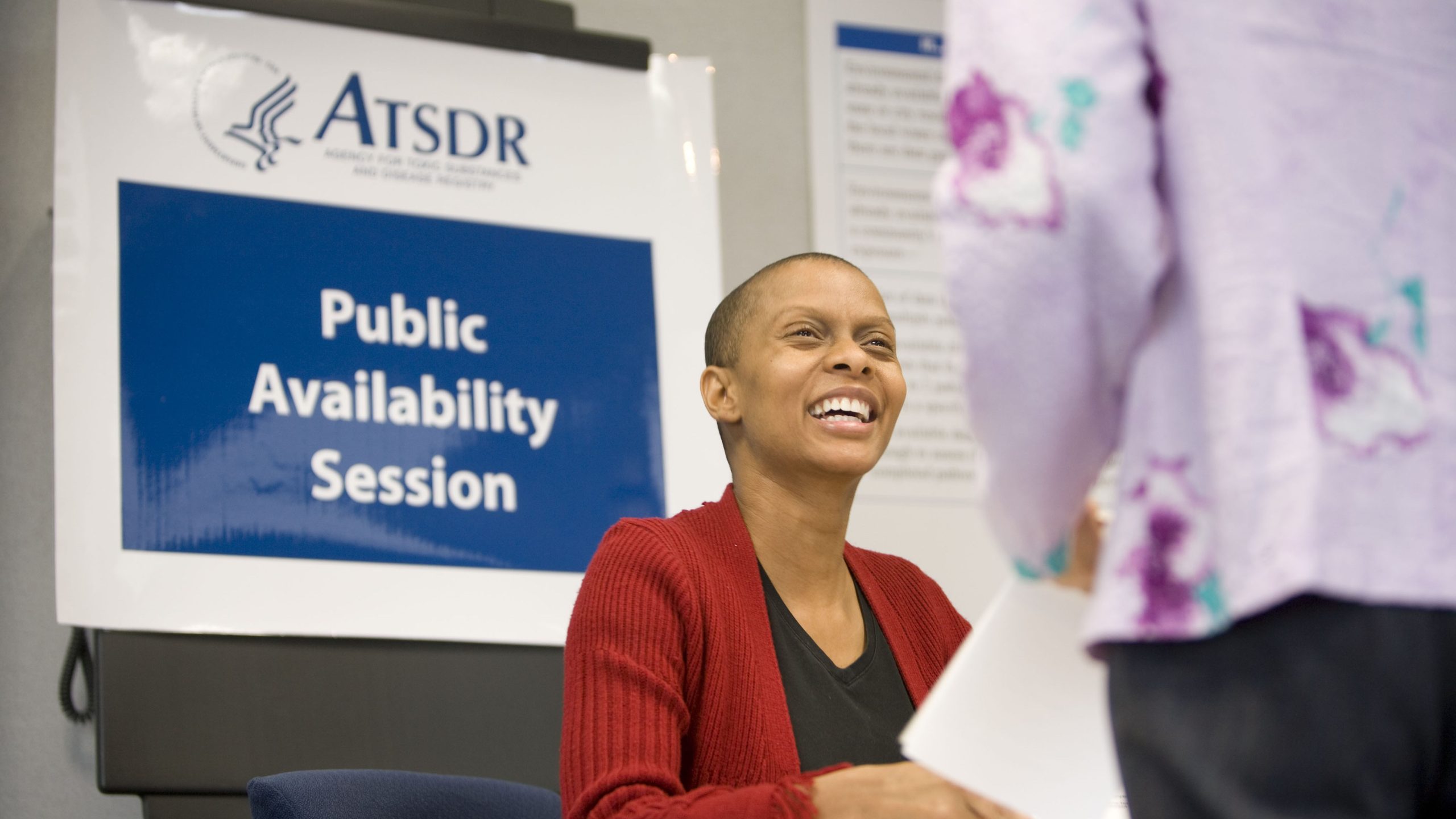 Photo of an African American woman about to addressing an ATSDR meeting participant during a breakout session.