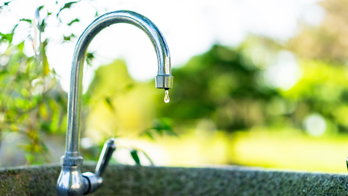 An outdoor sink in a tropical location with a dripping faucet.